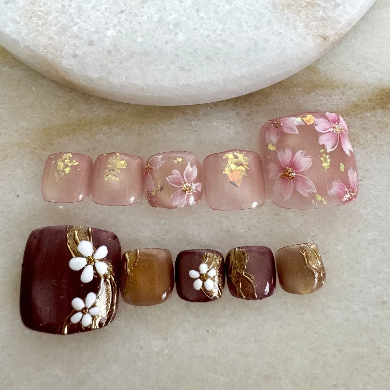ピンクに桜のような小花、ブラウンとホワイトに立体フラワーを合わせたフットネイル